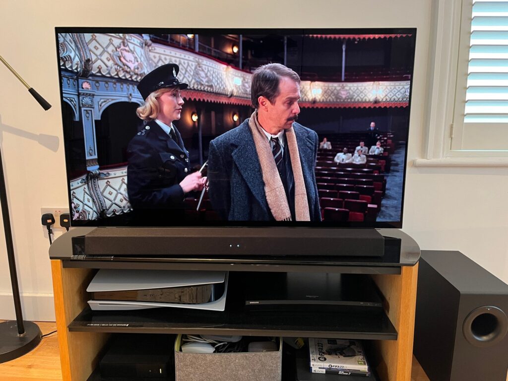 A Vizio TV and a soundbar placed next to each other, with cables being connected between them, illustrating the process of setting up the audio system.